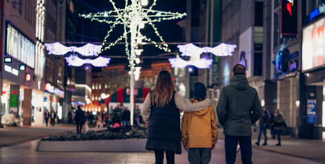 Familie schlendert durch vorweihnachtliche Bahnhofstraße