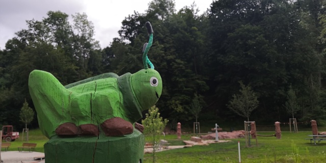Eine grüne Heuschreckenskulptur am Spielplatz Tal der Jugend