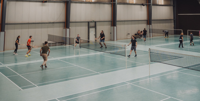Badminton hall with a view of the courts and people playing