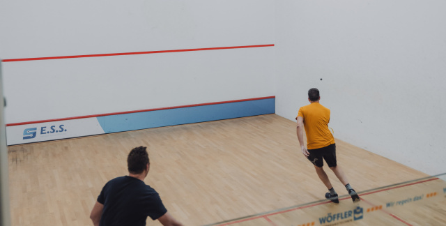Zwei Personen spielen in der Squash-Halle
