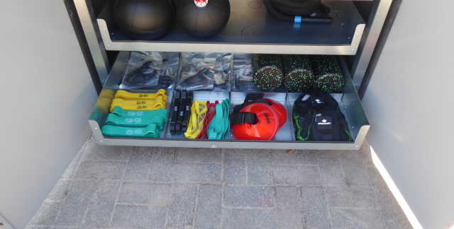 Sports box opened: drawer containing straps, fascia rolls and other items