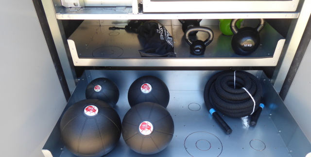 Sportbox open: drawer containing a rope and weight balls weighing two, four, six and eight kilograms.