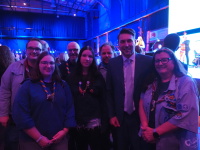 Eine Gruppe Pfadfindern steht neben einem Mann, alle lächeln