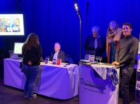 Mehrere Menschen stehen an einem Stand